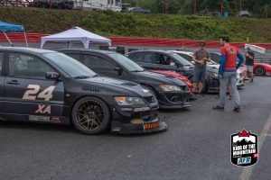 A group of race cars parked in a parking lot.