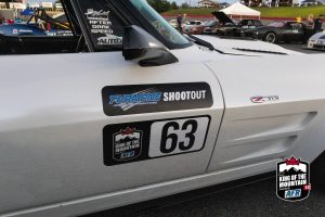 A white sports car is parked in a parking lot.