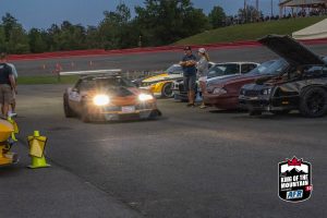 A group of cars parked at a race track.