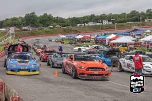 A group of cars parked on a race track.
