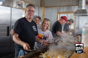 A group of people preparing food in a large kitchen.
