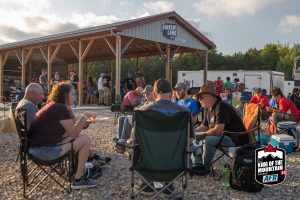 A group of people sitting on lawn chairs in front of a building.