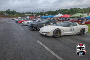 A group of cars parked on a race track.