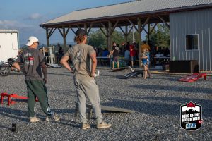 A group of people standing in a gravel lot.