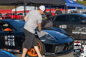 A man is washing his porsche gt3 at a race.