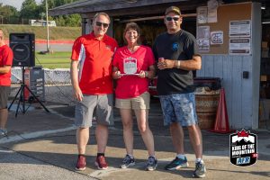 Three people posing for a picture at a race track.