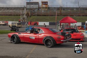 A red sports car is parked in a parking lot.