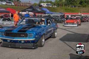 A blue and white muscle car parked in a parking lot.