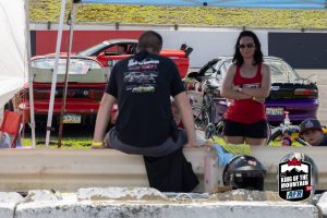 A man and woman sitting on a rail.