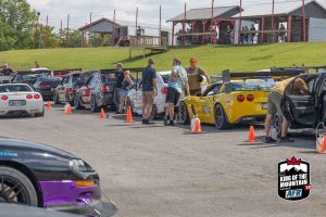 A group of people standing next to cars.