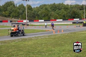 A group of people riding bicycles on a track with cones.
