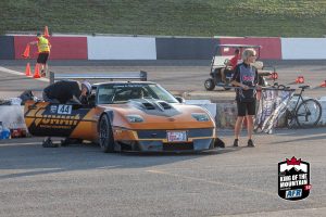 A man is standing next to a race car.