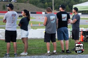 A group of people standing in line at a race track.