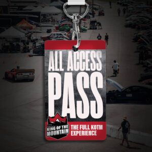 Close-up of an all-access pass lanyard for "King of the Mountain" event. Background shows a racetrack with cars, people, and tents.